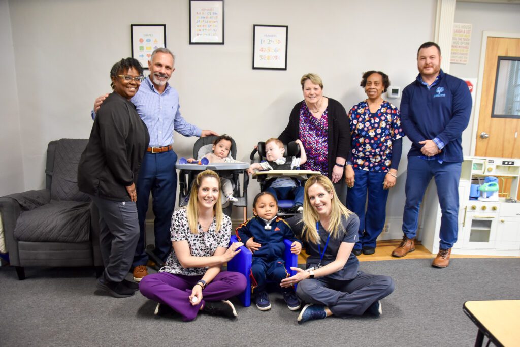 Dr. Chris Cianci and Ginny Craig with KenCrest's Transitional Care Homes for Medically Fragile Children's staff. // Photo by Aubrey Crompton. 