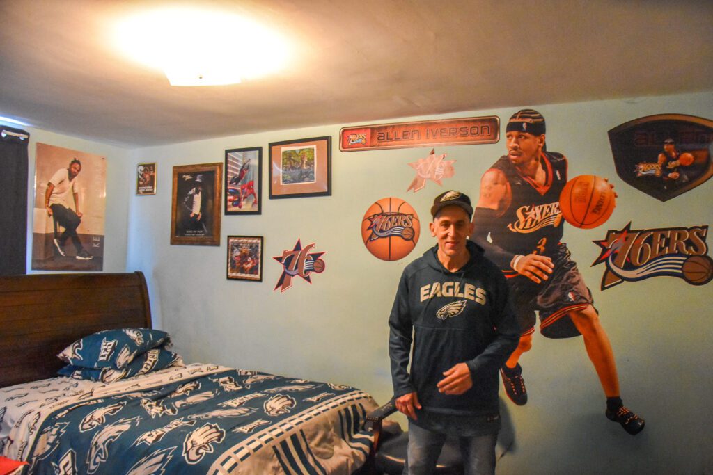 Arturo in his room with all his Philly sports decor