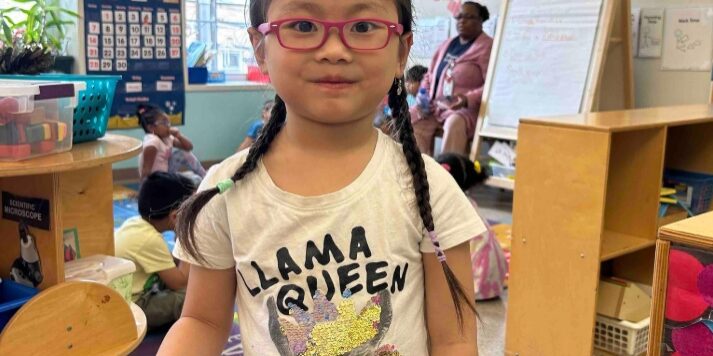 A child posing with her new glasses. // Photo courtesy of KenCrest