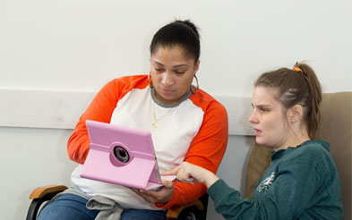 2 girls looking at an ipad.